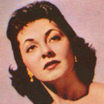 An old color photo of a white woman with dark hair gazing into the middle distance